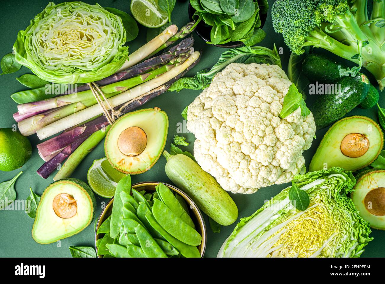 Healthy Diet Spring food background. Assortment of fresh raw organic green vegetables - broccoli, cauliflower, zucchini, cucumbers, asparagus, spinach Stock Photo