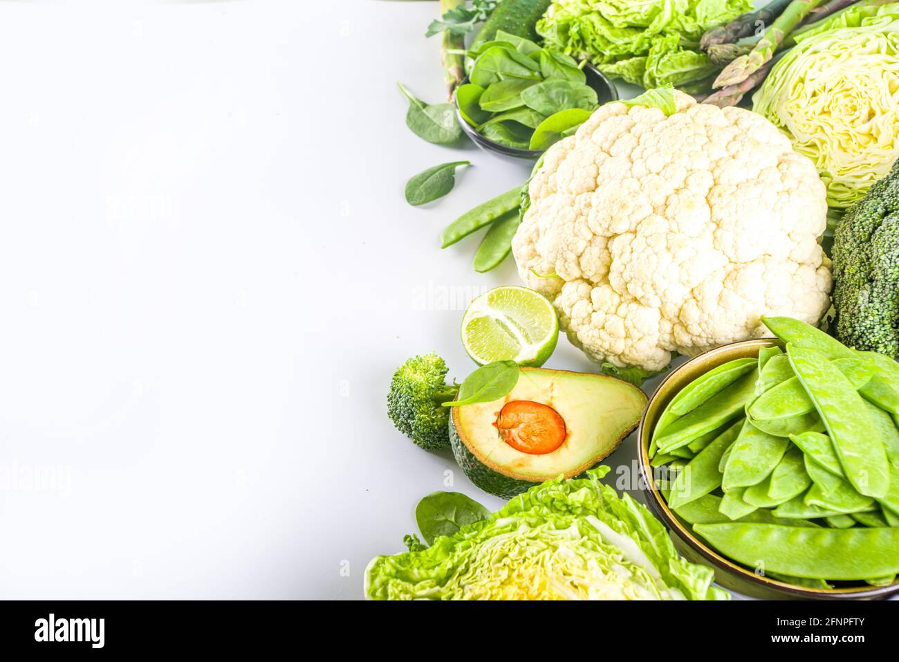 Healthy Diet Spring food background. Assortment of fresh raw organic green vegetables - broccoli, cauliflower, zucchini, cucumbers, asparagus, spinach Stock Photo