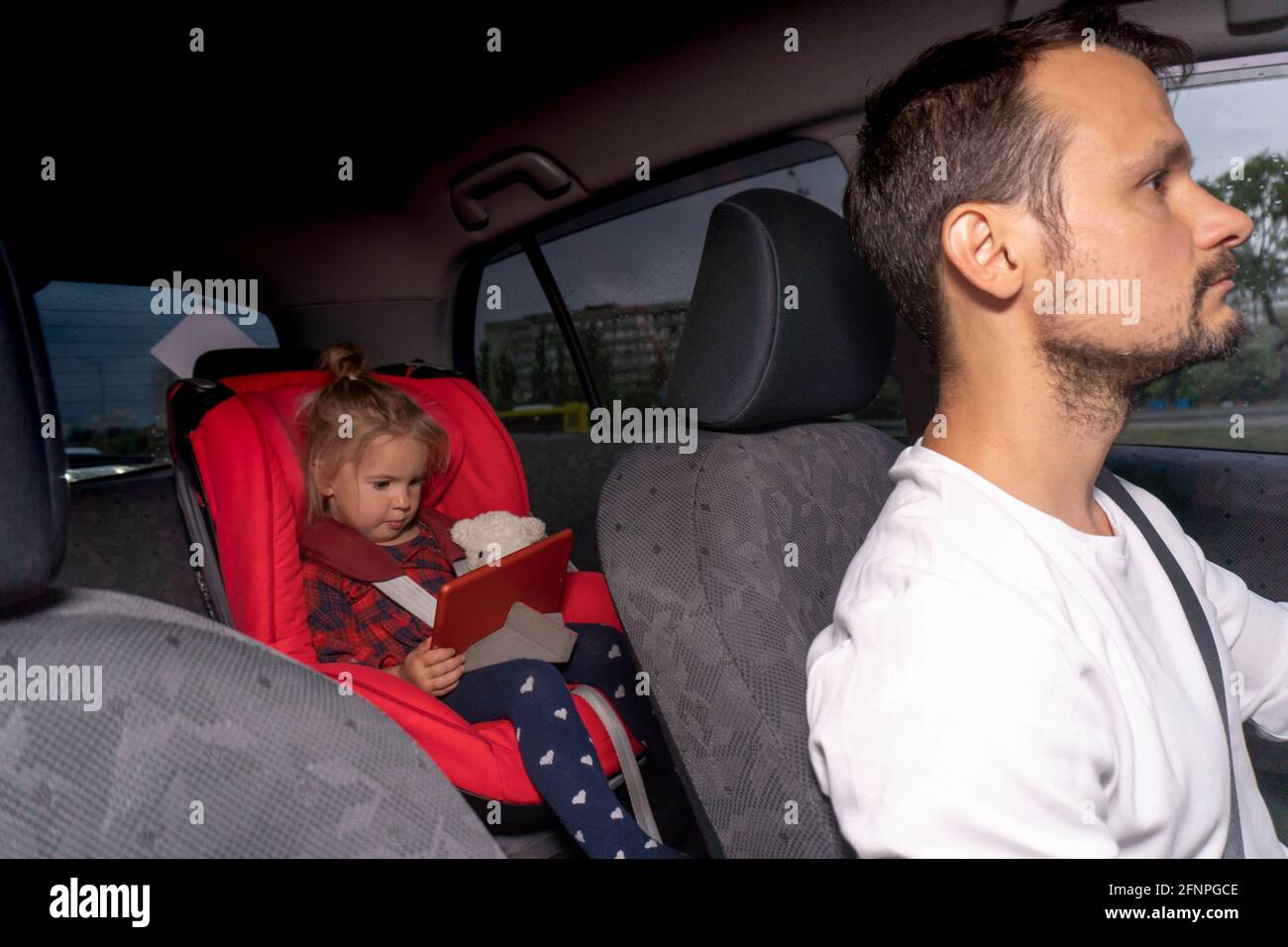 Cute caucasian little child sitting at safety car seat for children Stock Photo