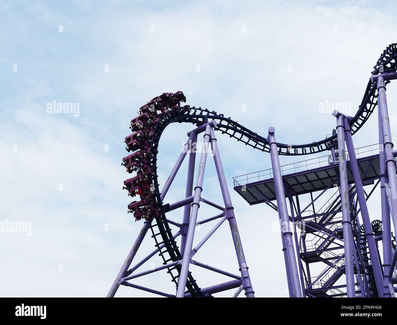 Russia, Sochi 16.04.2021. Fragment of extreme attraction roller coaster  with people riding on it high against blue cloudy sky Stock Photo - Alamy