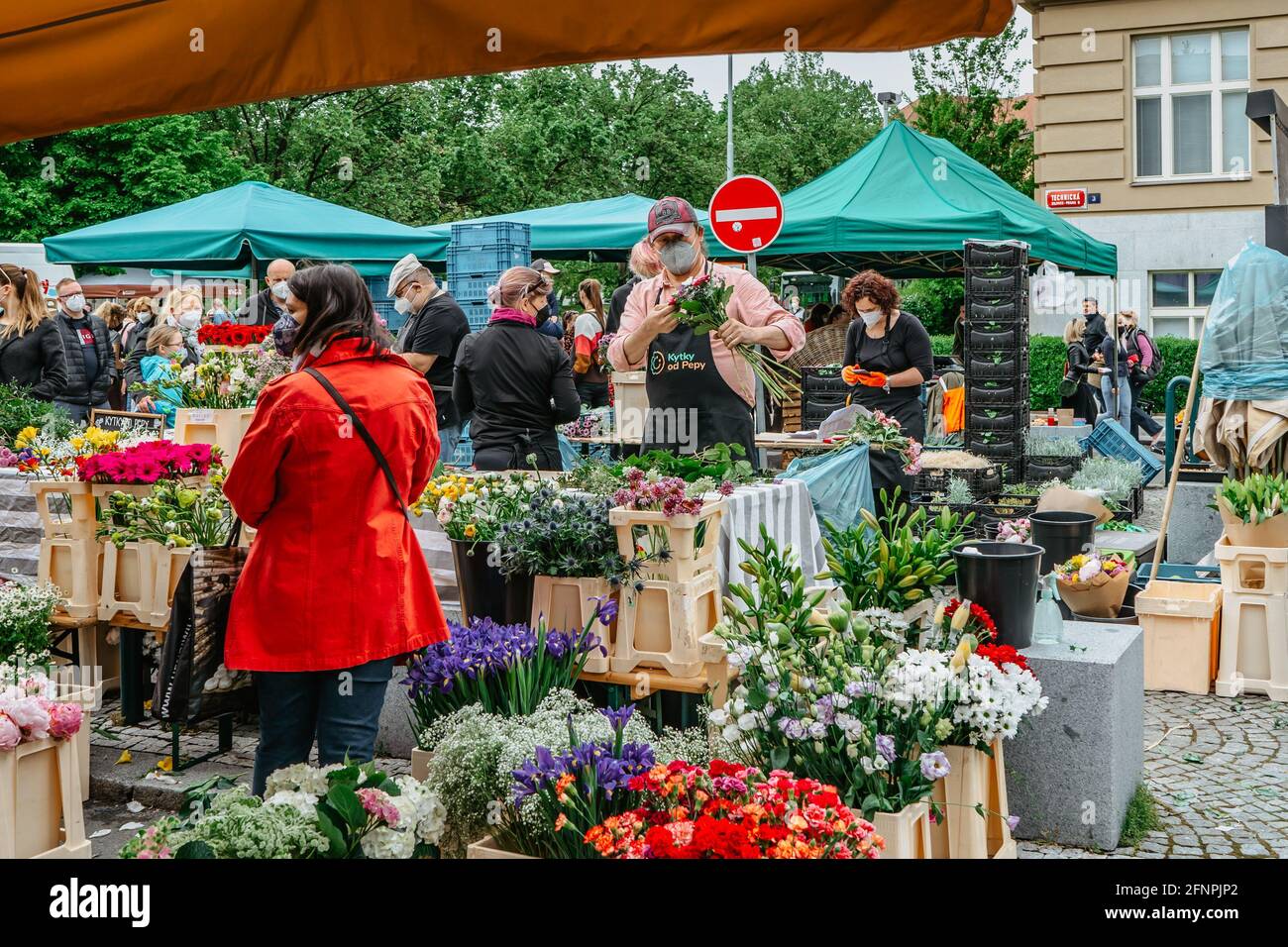 Prague, Czech Republic - May 15, 2021.Traditional farmers market in quarter of Dejvice. Seller and customers in surgical masks against covid19 virus Stock Photo