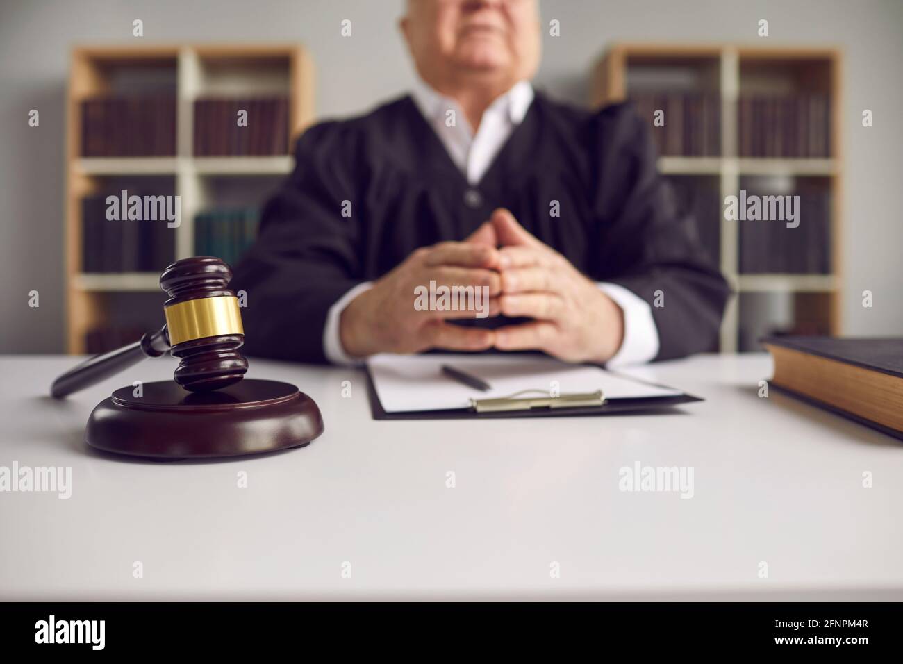 Close up of a wooden gavel lying on a sound block on a judges desk in the courtroom. Stock Photo