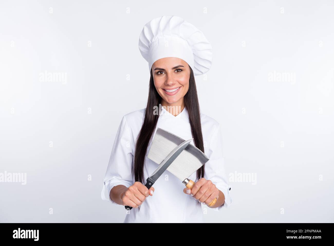 Portrait of charming lady hands hold crossed knives toothy smile look camera isolated on white color background Stock Photo