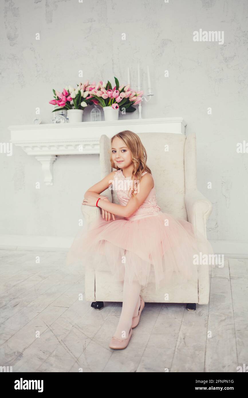 fashionable little girl in a stylish dress sitting in a chair Stock ...
