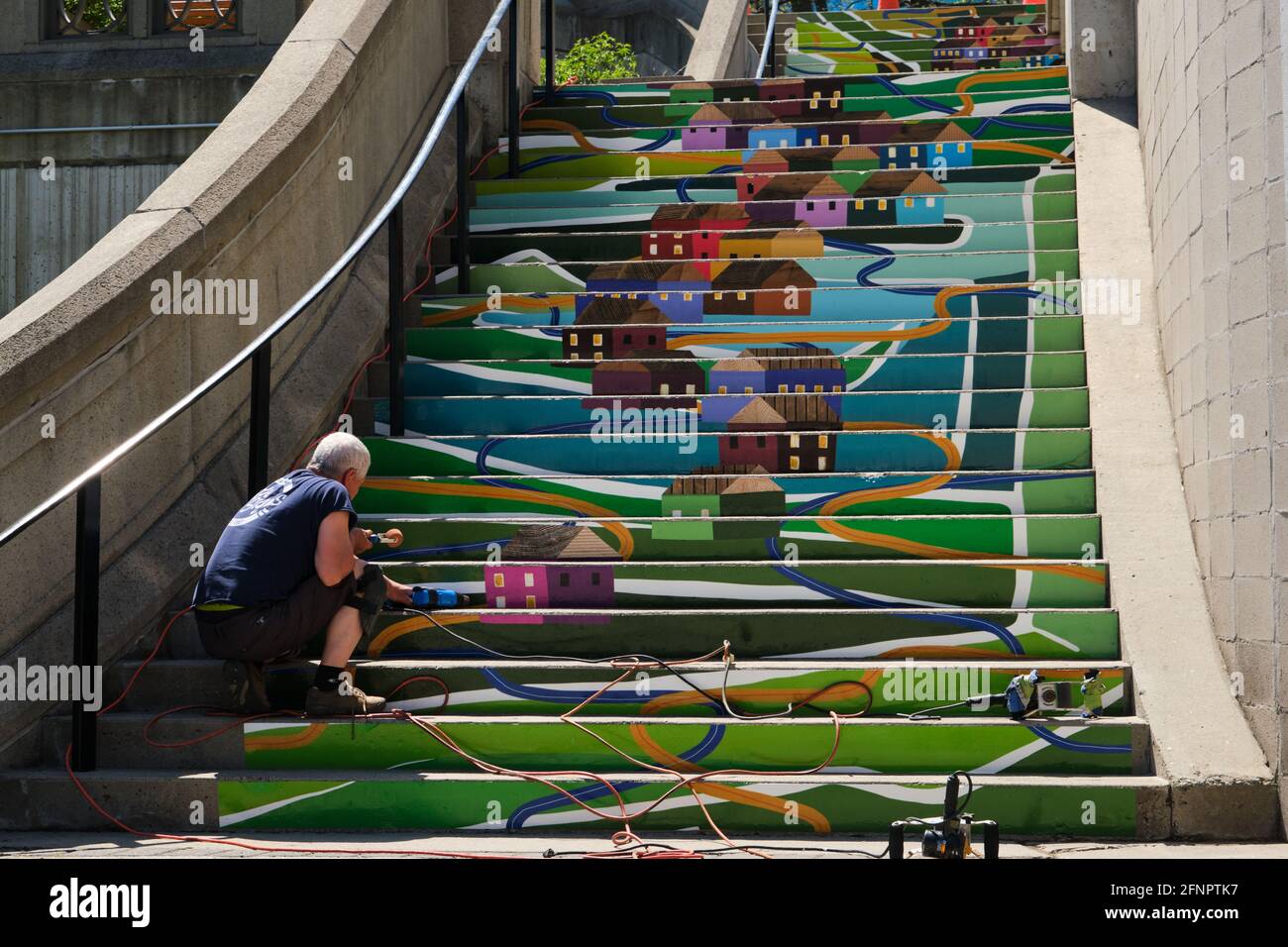 Graphic workers doing paint touch up on urban designed public stairs with image of old Ottawa. Stock Photo