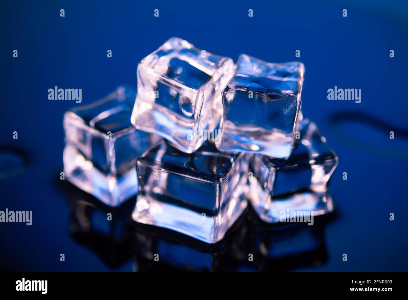 Wet ice cubes on dark blue background Stock Photo