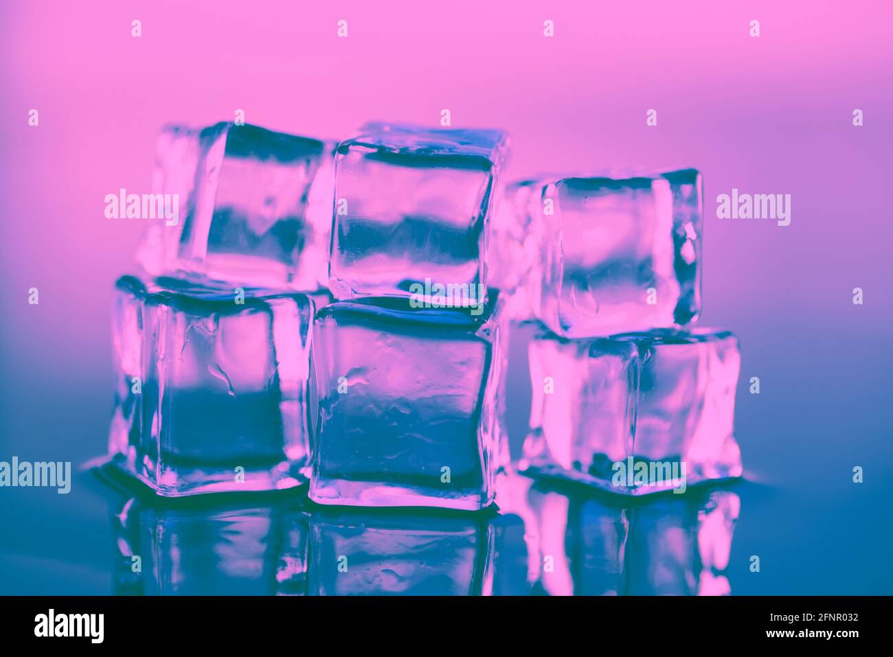Wet ice cubes in neon light, close up Stock Photo