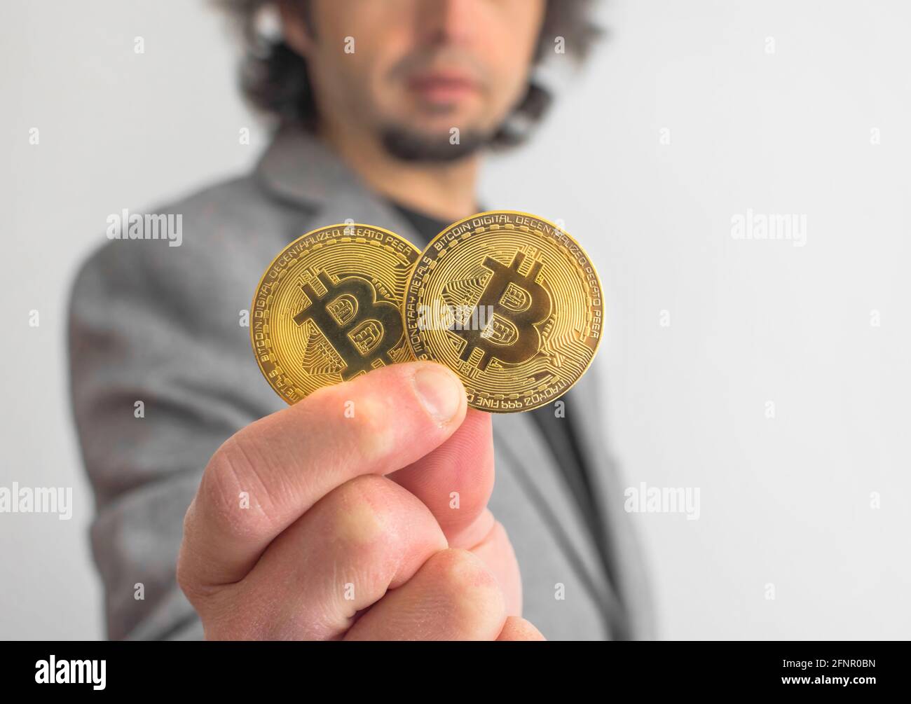 Businessman wearing a suit, holding Bitcoin BTC crypto currency gold coins,  new virtual money concept. Mining or blockchain technology Stock Photo -  Alamy