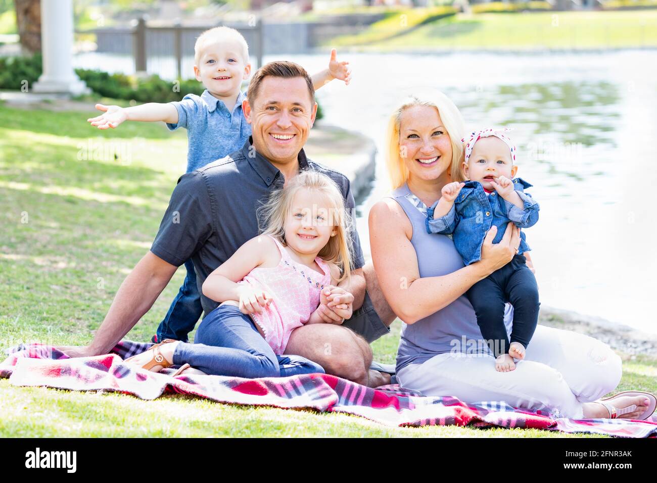 Happy Young Caucasian Family Portrait In The Park. Stock Photo