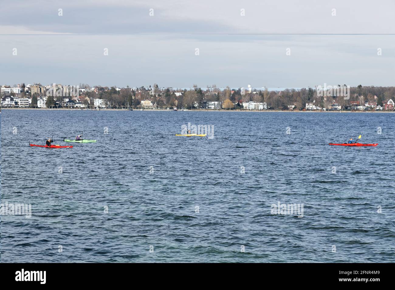 kayakers on lake bodensee in different colored boats, the lake is very popular with hobby sportsmen, daytime, sunshine Stock Photo