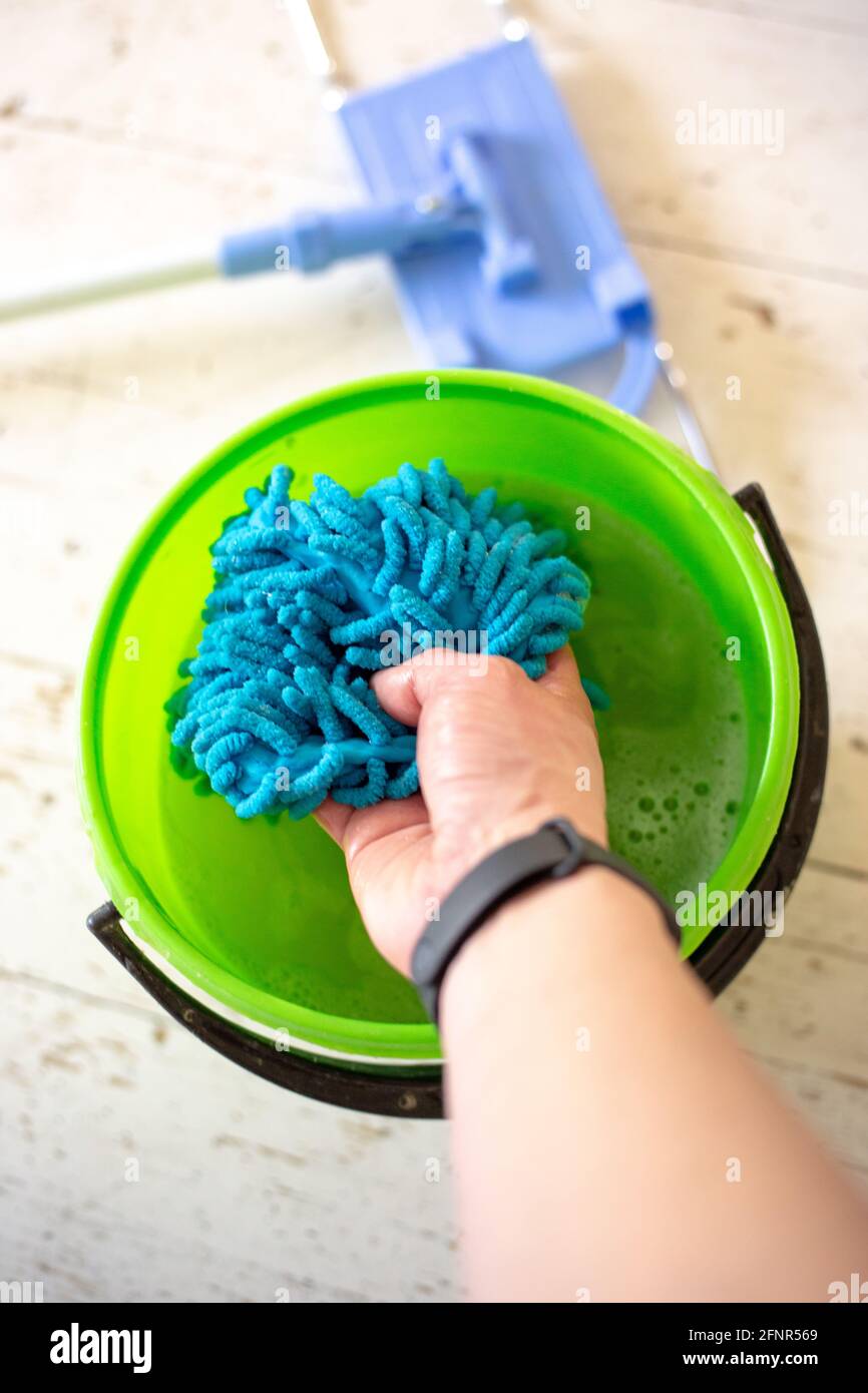Washing a doormat in a bucket of water. Room cleaning Stock Photo Alamy