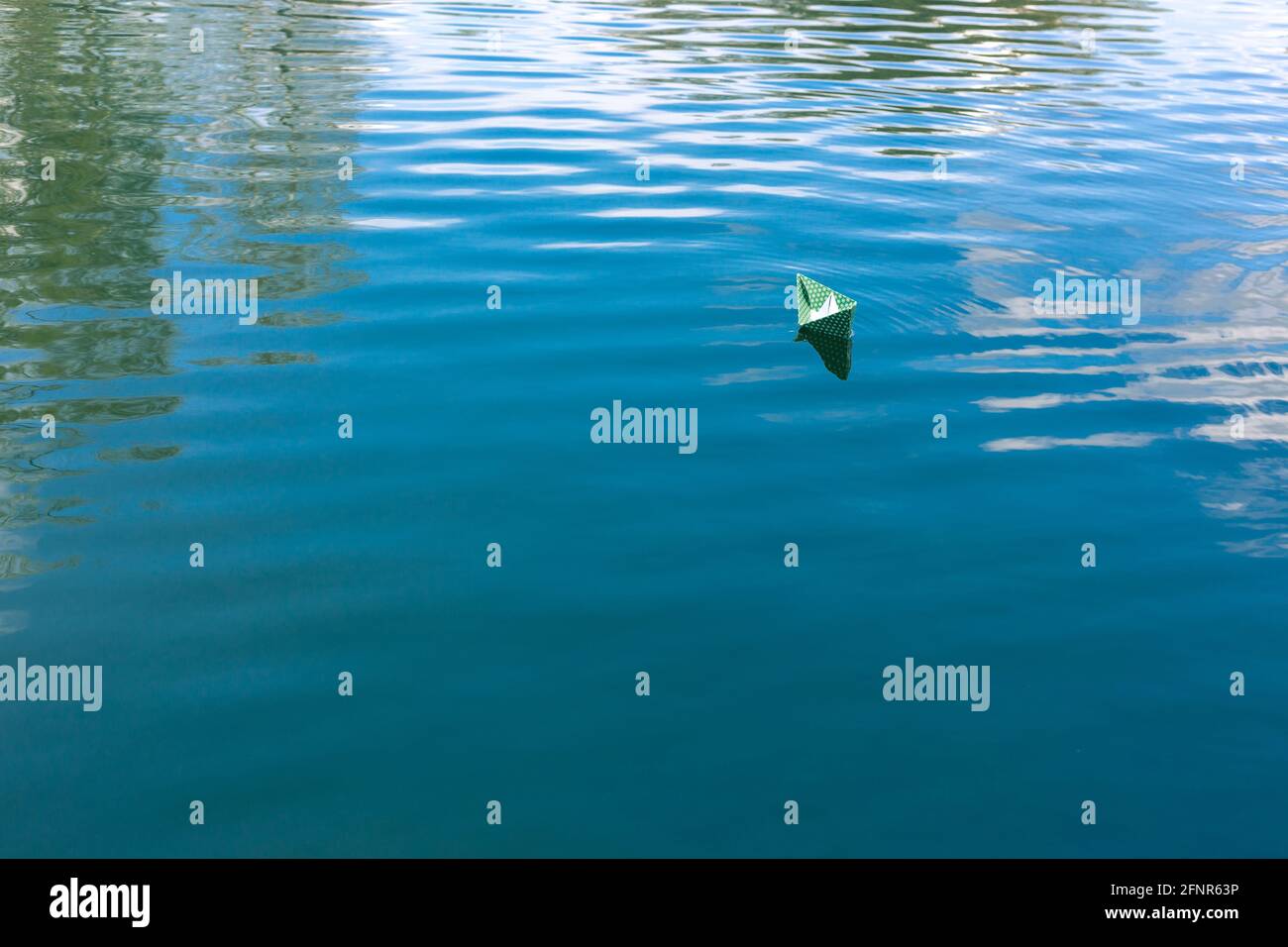 White paper skiffs float on water. Origami Stock Photo - Alamy