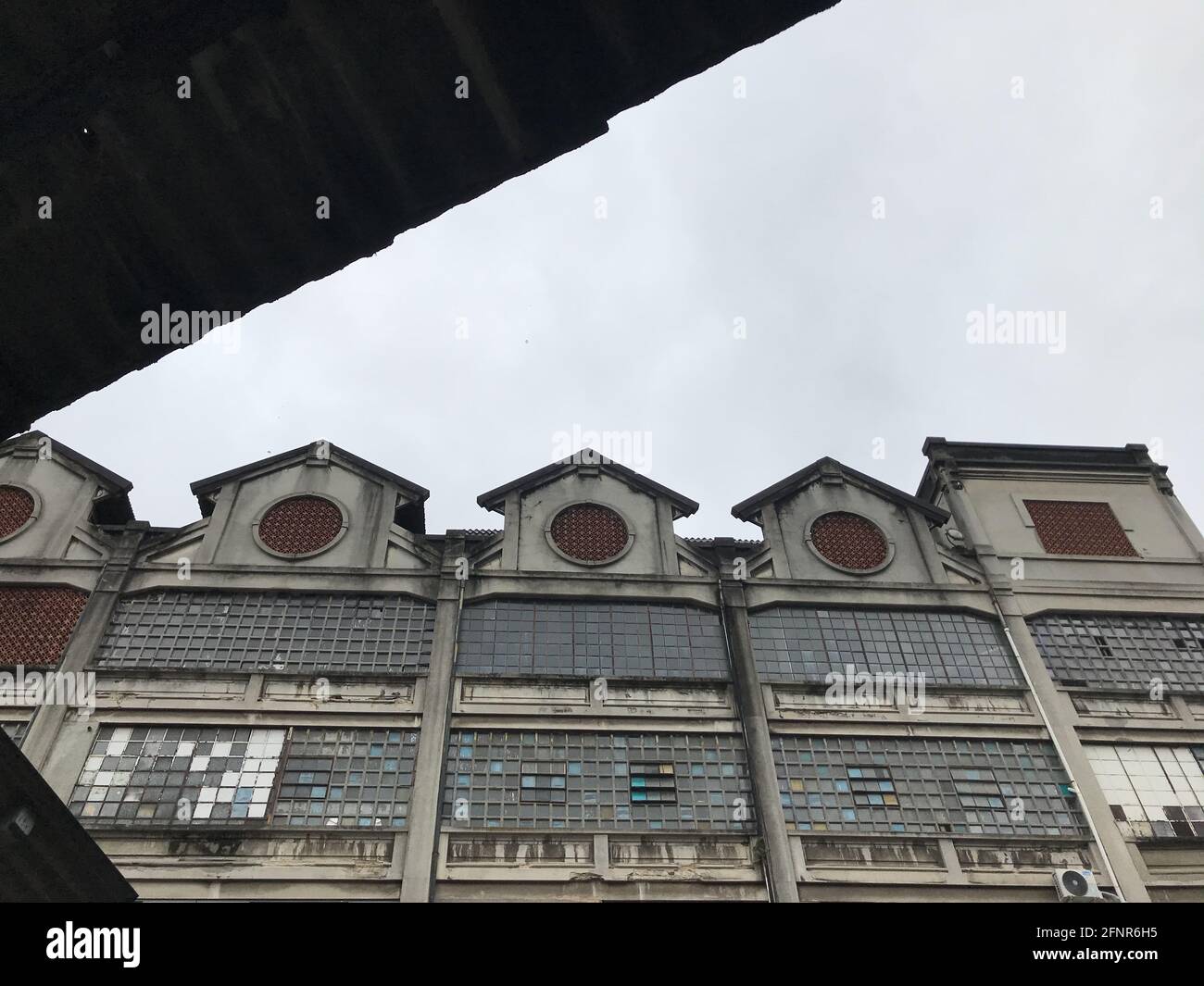 Low angle shot of an old building with rusted facade and broken windows ...