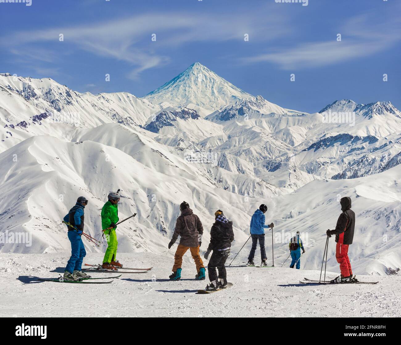 The view of skiers and Mount Damavand from Darbandsar ski resort in Tehran, Iran. Stock Photo