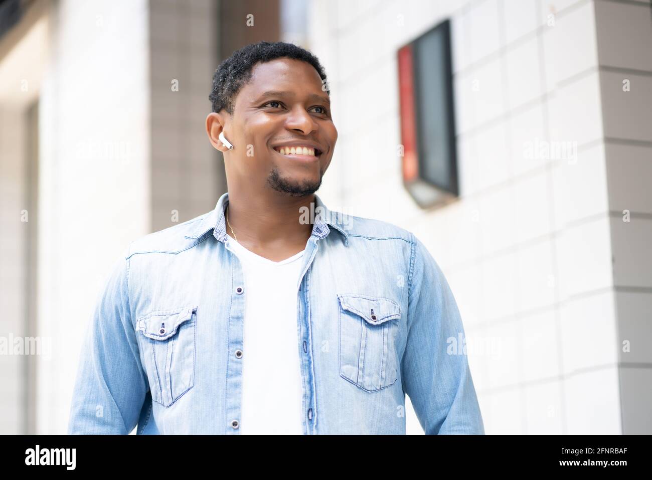 Happy african man walking listening hi-res stock photography and images ...