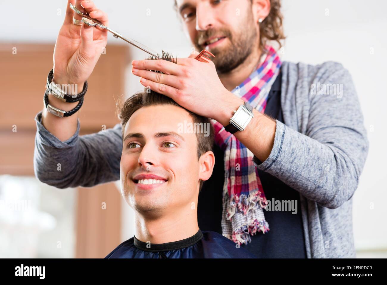 Barber trimming man hair in haircutter shop Stock Photo Alamy