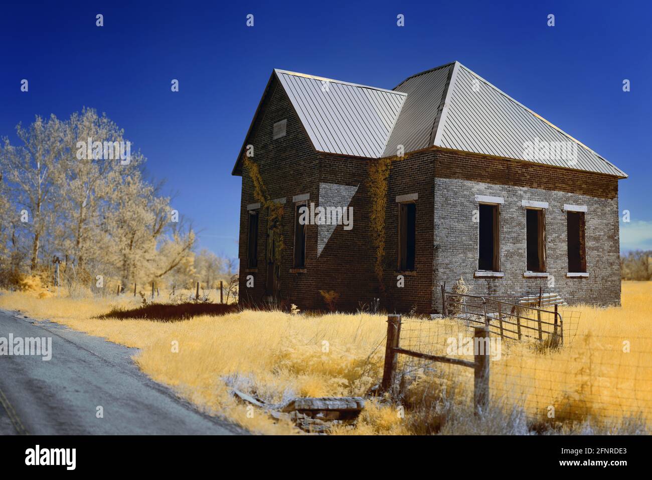 An old schoolhouse outside of Columbus, IN as imaged in false color 665nm infrared light.  The sky is cloudless and deep blue.  Light orange foliage. Stock Photo