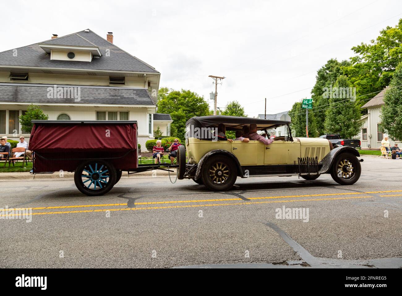An antique Auburn classic automobile pulls a camper trailer through ...