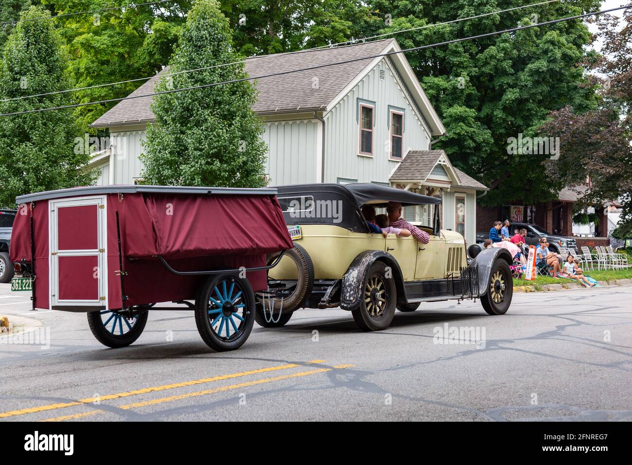 An antique Auburn classic automobile pulls a camper trailer through ...