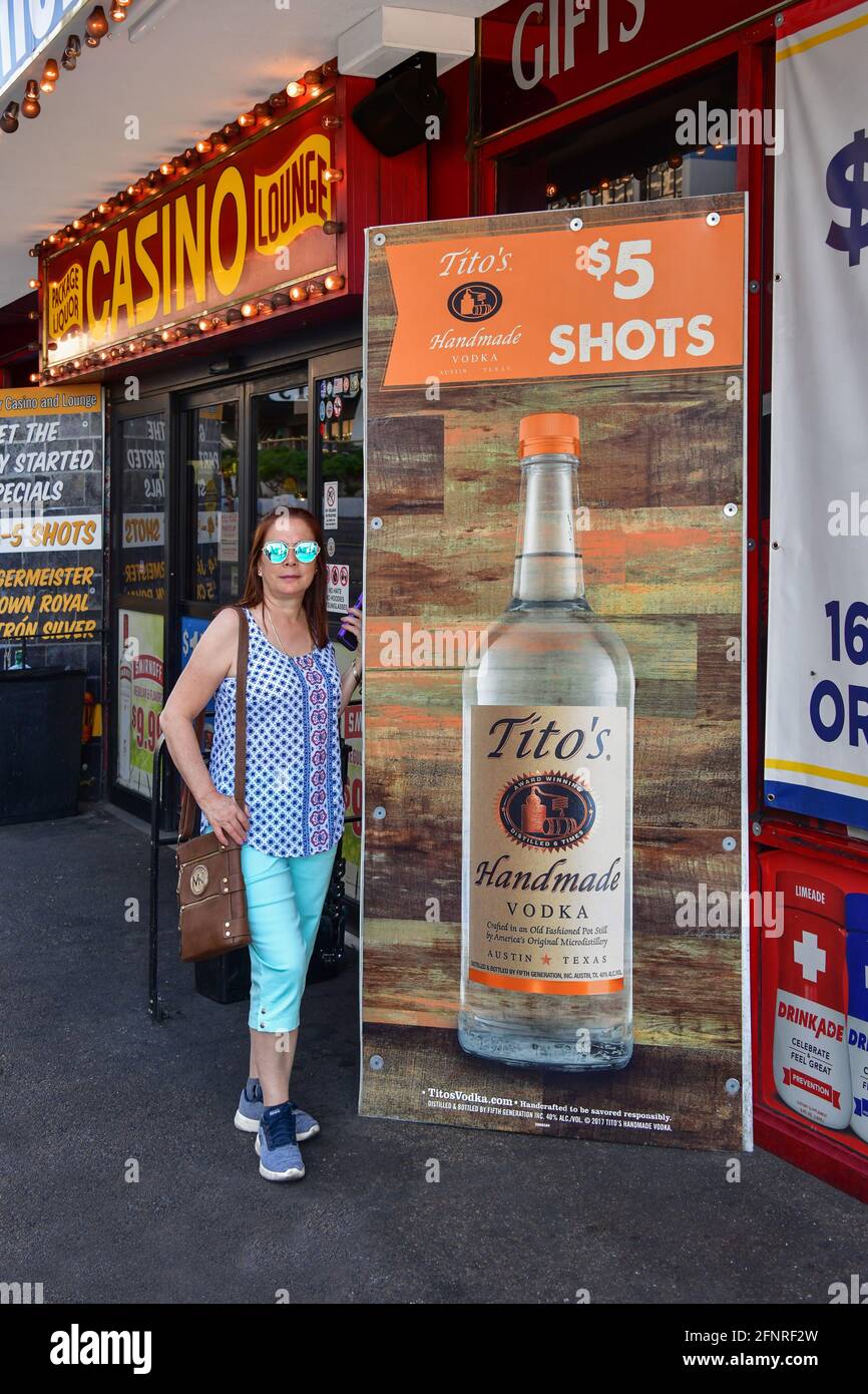 Nevada USA 09-30-18 A lady poses next to a colorful poster of the famous drink Tito's Handmade Vodka at the Stage Door Casino liquor store Las Vegas Stock Photo