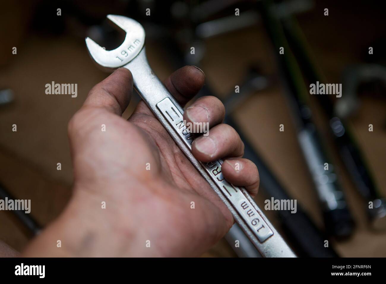 Auto mechanic holding wrench (auto repair, car repair) - USA Stock Photo