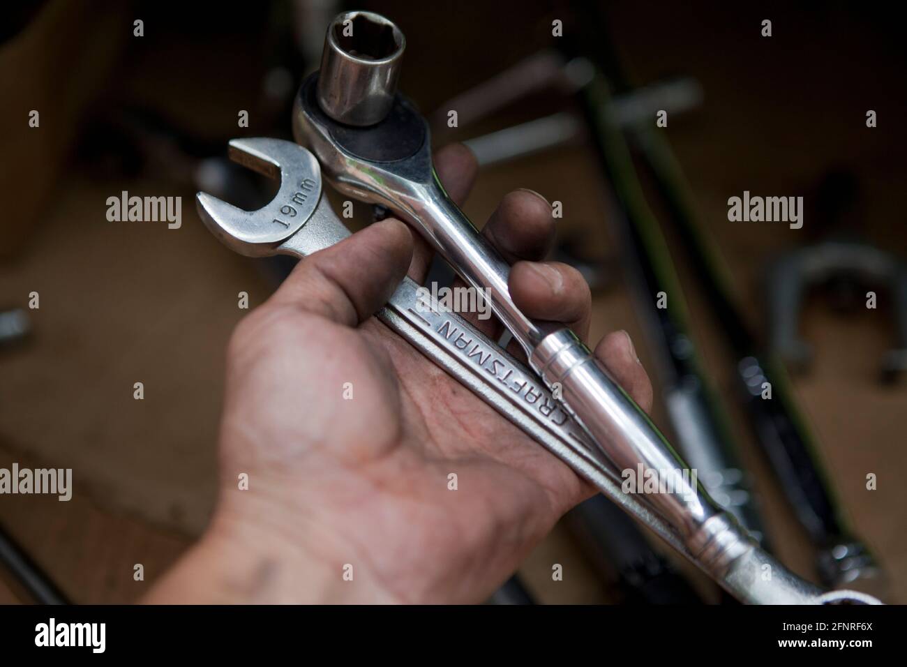 Auto mechanic holding wrenches (auto repair, car repair) - USA Stock Photo