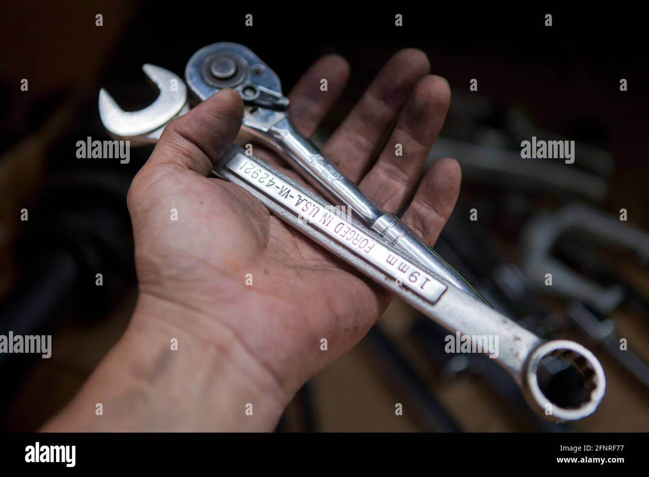 Auto mechanic holding wrenches (auto repair, car repair) - USA Stock Photo