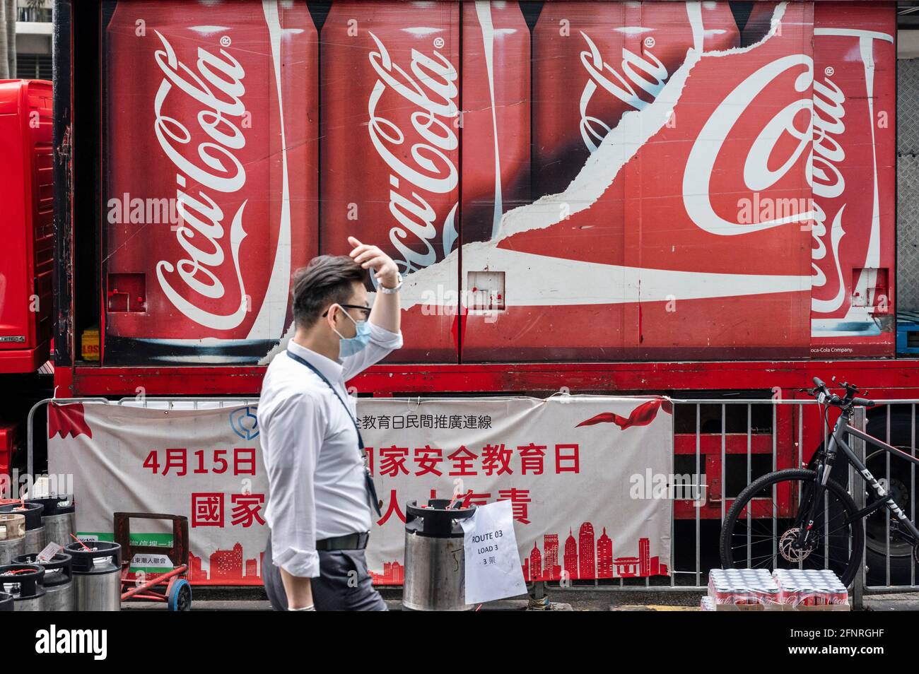 A pedestrian walks past a delivery truck of the American soft drink