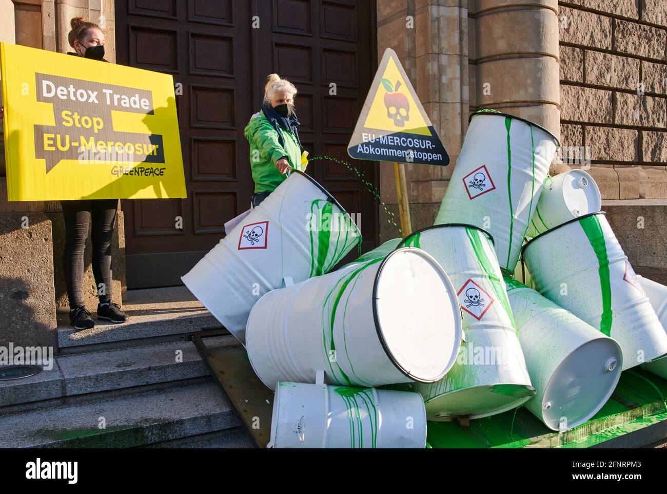 Berlin, Germany. 19th May, 2021. Barrels symbolically painted as poison barrels with green paint stand in front of the Ministry of Economy during a Greenpeace action for the stop of the EU-Mercosur trade agreement. The environmental organisation Greenpeace has published a new study on pesticides in fruit, one day before the EU Trade Ministers' Council. It tested 70 fruits, including mangoes, papayas, melons and figs, from Brazil. Credit: Annette Riedl/dpa/Alamy Live News Stock Photo