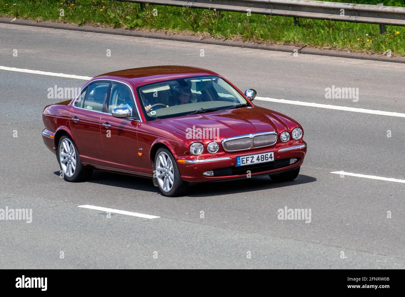 2007 red Jaguar XJ 2.7 TDVI SOVEREIGN 4d AUTO 206 BHP Saloon Diesel Automatic; Vehicular traffic, moving vehicles, cars, vehicle driving on UK roads, motors, motoring on the M6 motorway highway UK road network. Stock Photo