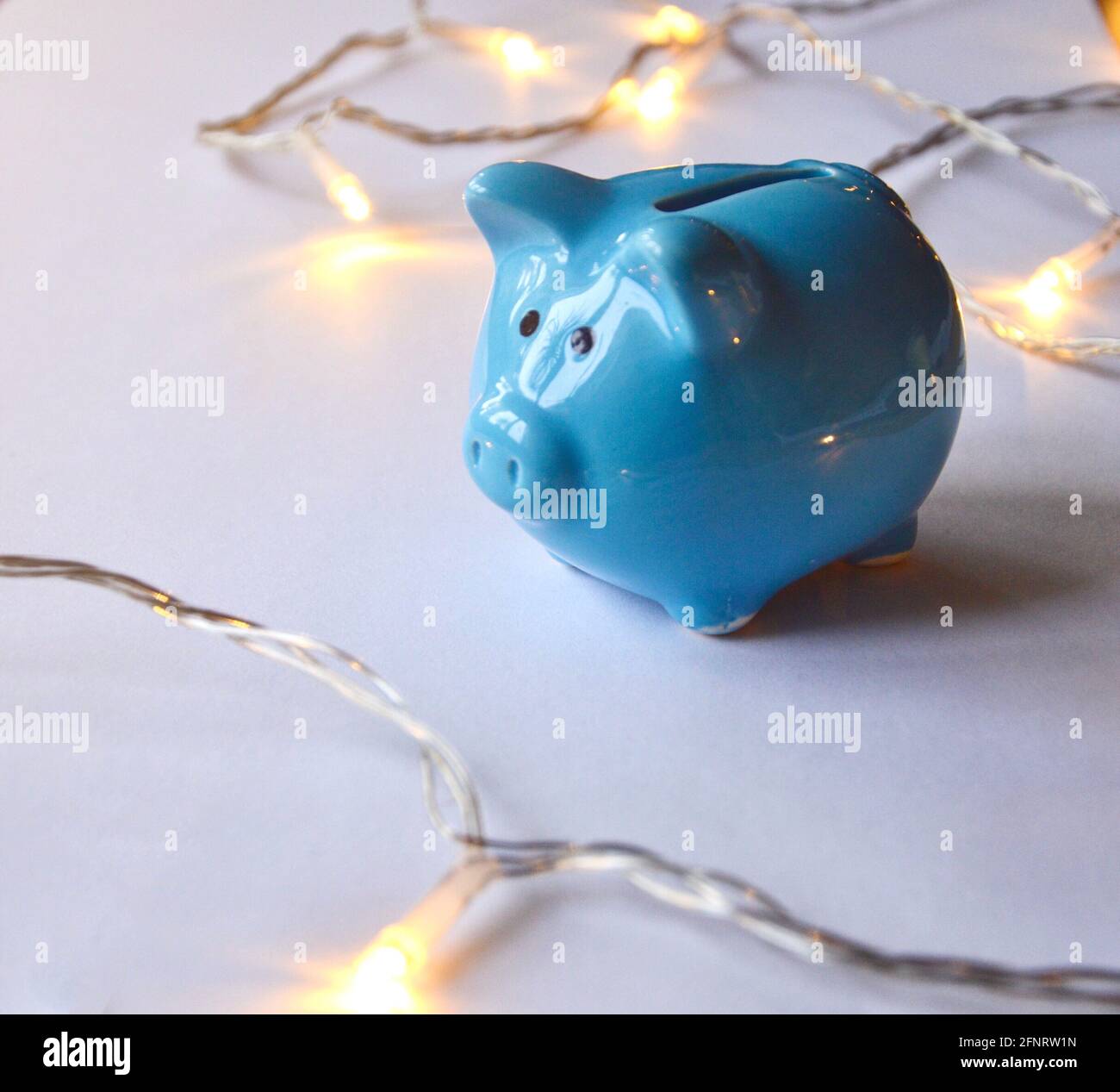 Photo of a blue piggy bank and lights on white background Stock Photo ...