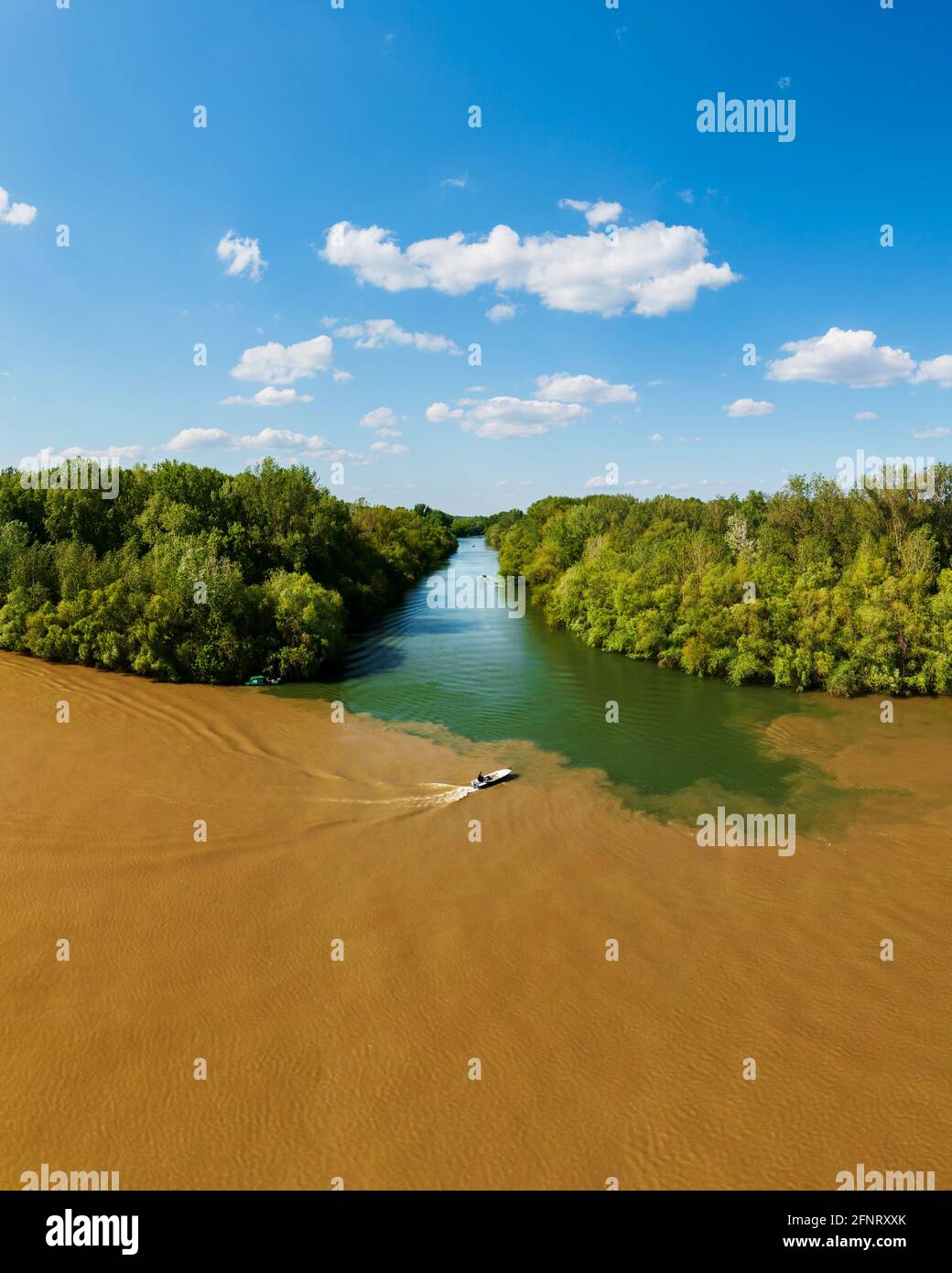 Tisza and Koros River estuary. It has amazing water mixing texture photo with a boat in spring time. Stock Photo