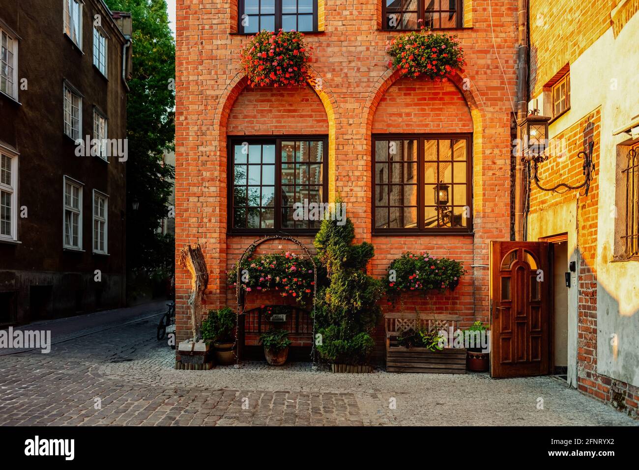 Cozy old european city narrow street and facade view of old building with  flowers which covers a brick wall in a sunny day. Gdansk, Poland Stock  Photo - Alamy, image size:1300x957
