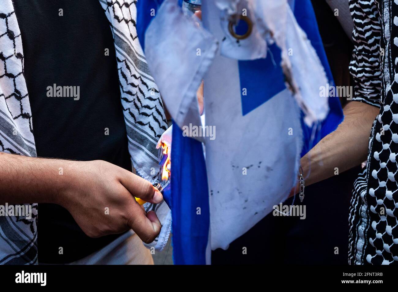 Washington, DC, USA, 18 May, 2021.  Pictured: Protesters light an Israeli flag on fire during a march against Israel’s actions in Gaza and Jerusalem.  Credit: Allison Bailey / Alamy Live News Stock Photo