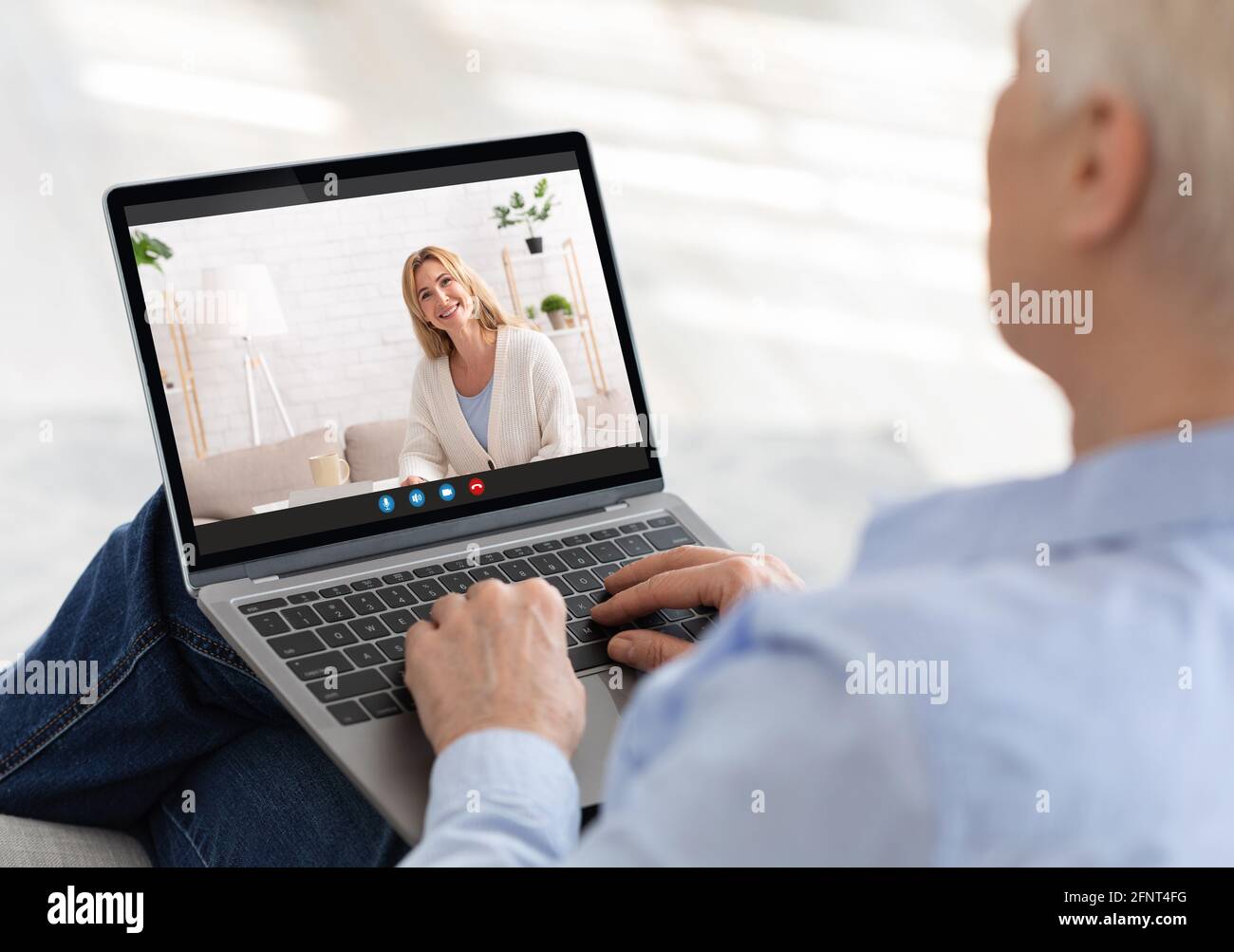 Elderly woman using laptop to communicate to her grownup daughter online, making video call with family member, indoors Stock Photo
