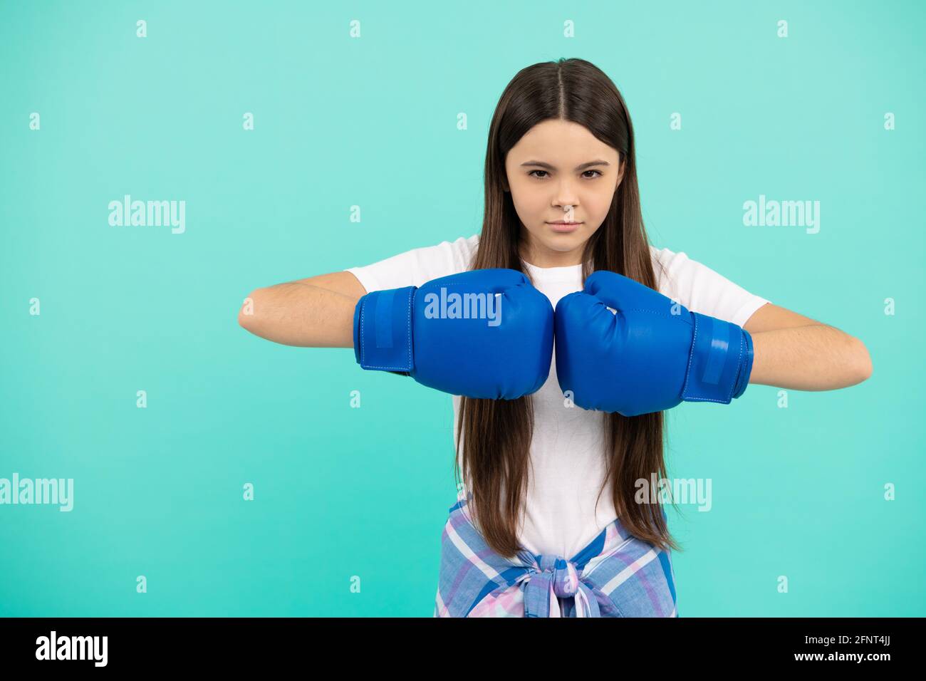 confident child boxer in boxing gloves during sport training, copy space, determination Stock Photo