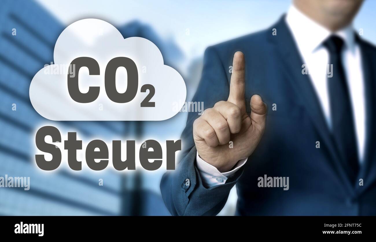 CO2 Steuer (in german carbon tax) concept is shown by businessman. Stock Photo