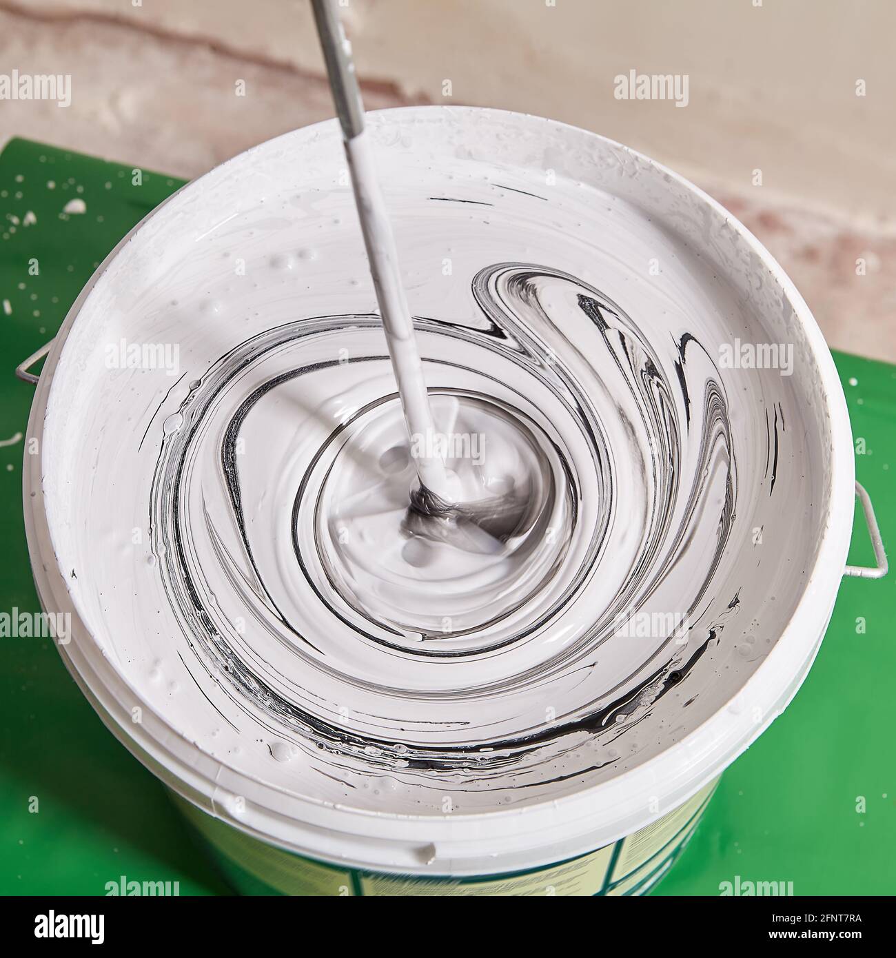 Mixing white paint with black pigment to obtain gray color Stock Photo