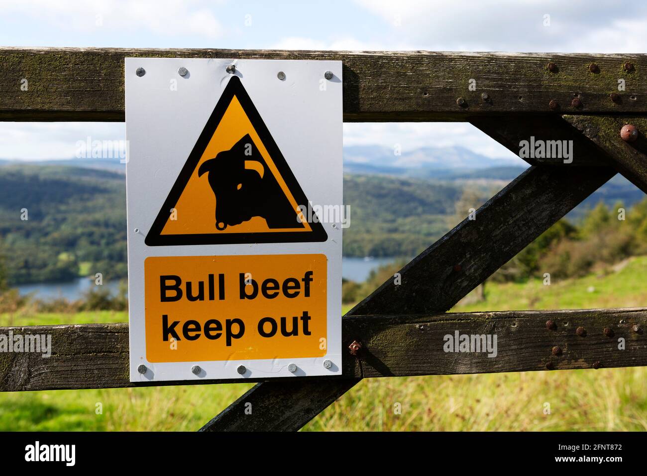 Sign warning people to keep out of a field in Cumbria, England. The field has a bull. Stock Photo