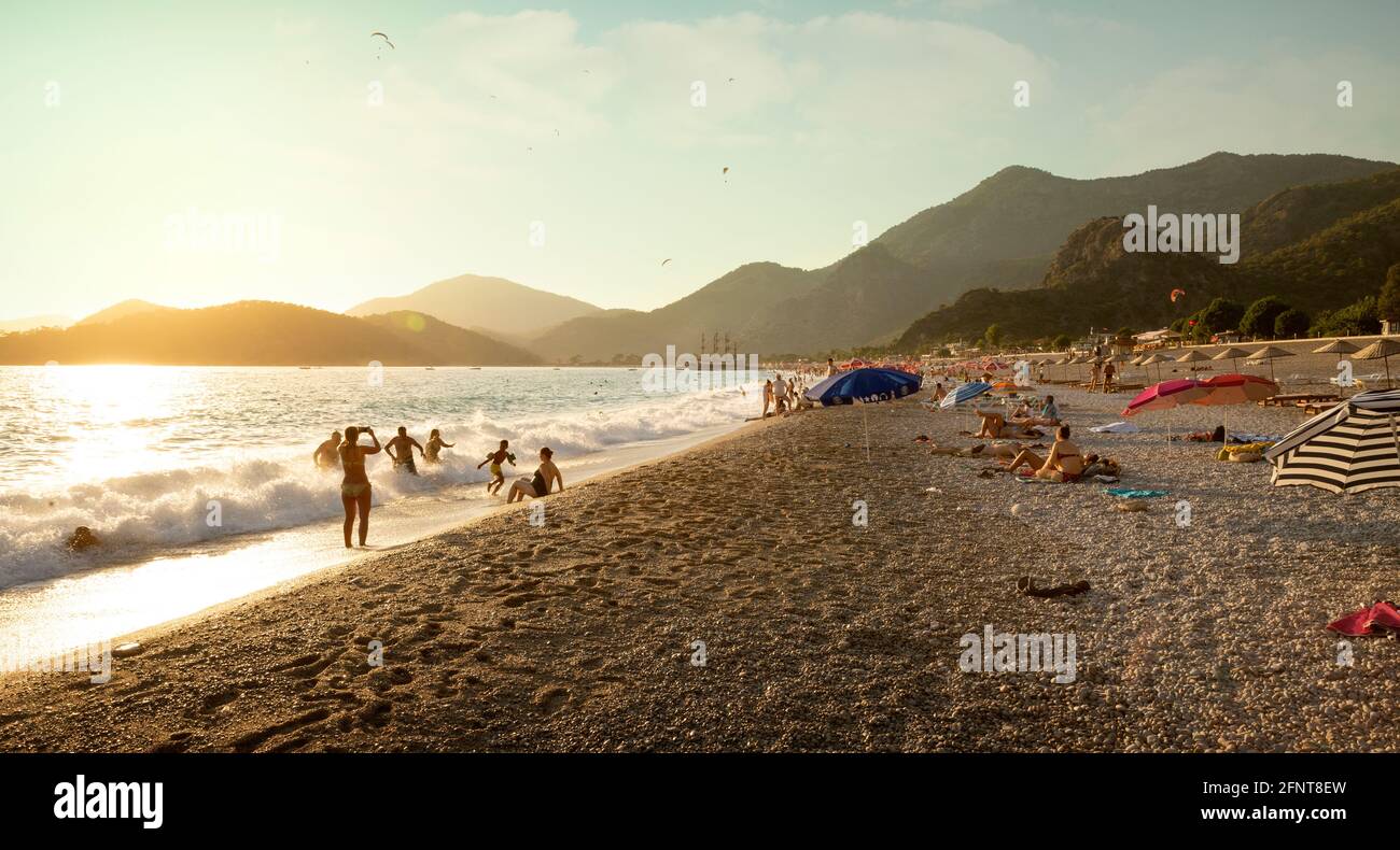 Oludeniz, Turkey - August 13, 2017: Tourists playing on the beach in Oludeniz at sunset, Turkey Stock Photo