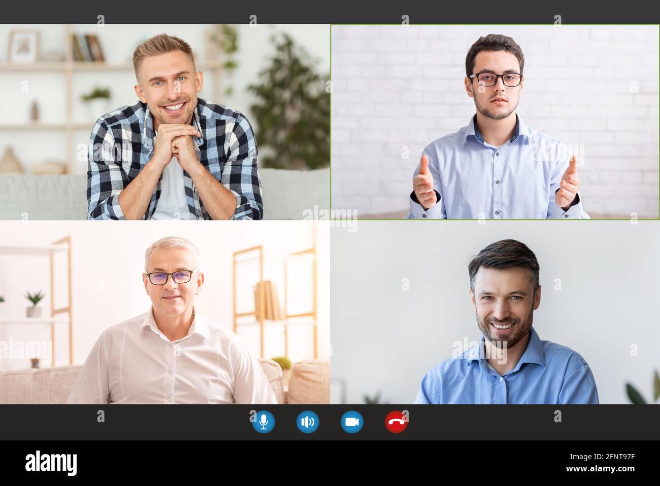 Monitor screen with cheerful men having group video chat, speaking to each other via internet Stock Photo