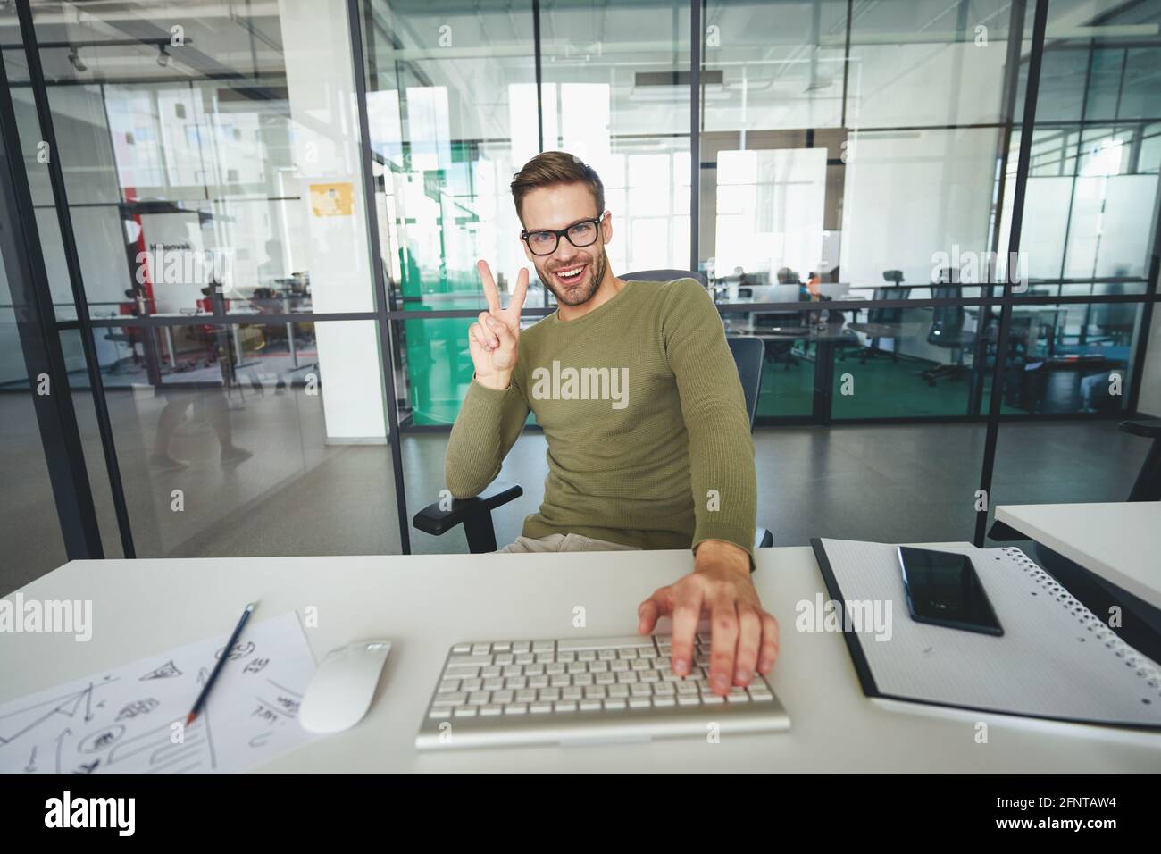 Young man gesturing actively in front of a web-camera Stock Photo