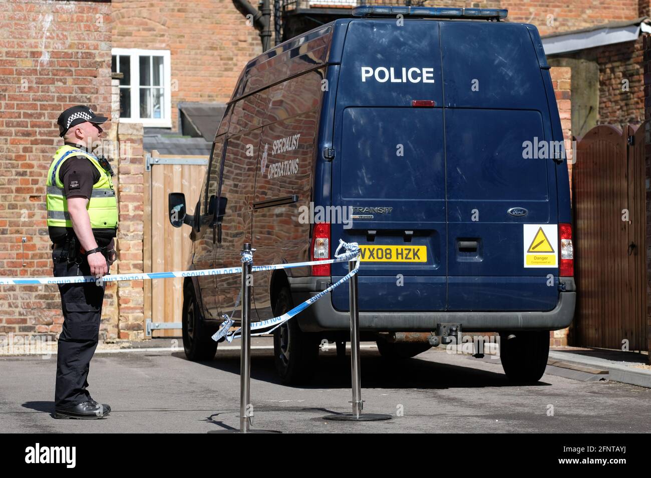 Gloucester, Gloucestershire, UK - Wednesday 19th May 2021 - Police officer at the rear of the Clean Plate cafe as Police begin excavations in the search for Mary Bastholm who went missing in 1968 aged just 15 years old and who may have been a victim of serial killer Fred West. Photo Steven May / Alamy Live News Stock Photo