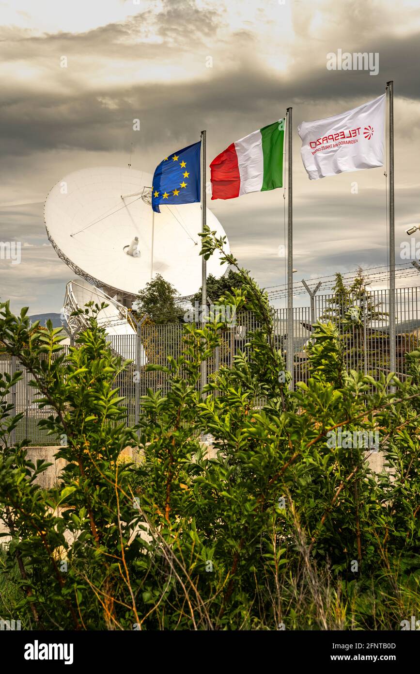 Telespazio space center in Fucino. Satellite dish for the in-orbit satellites and telecommunications services.Flags of Europe,Italy and the Telespazio. Stock Photo