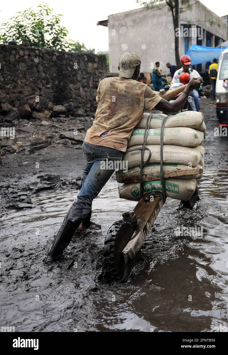 A Congolese man pushing his Chukudu through a muddy road in Goma, North Kivu province, D.R.C Stock Photo