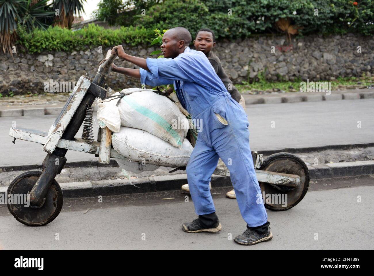 A Congolese man pushing his loaded chukudu in Goma, North Kivu province, D.R.C Stock Photo