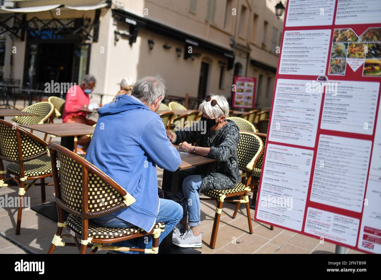 People enjoy a coffee on a terrace in the morning on May 19, 2021 in Cannes, France. Bars, shops