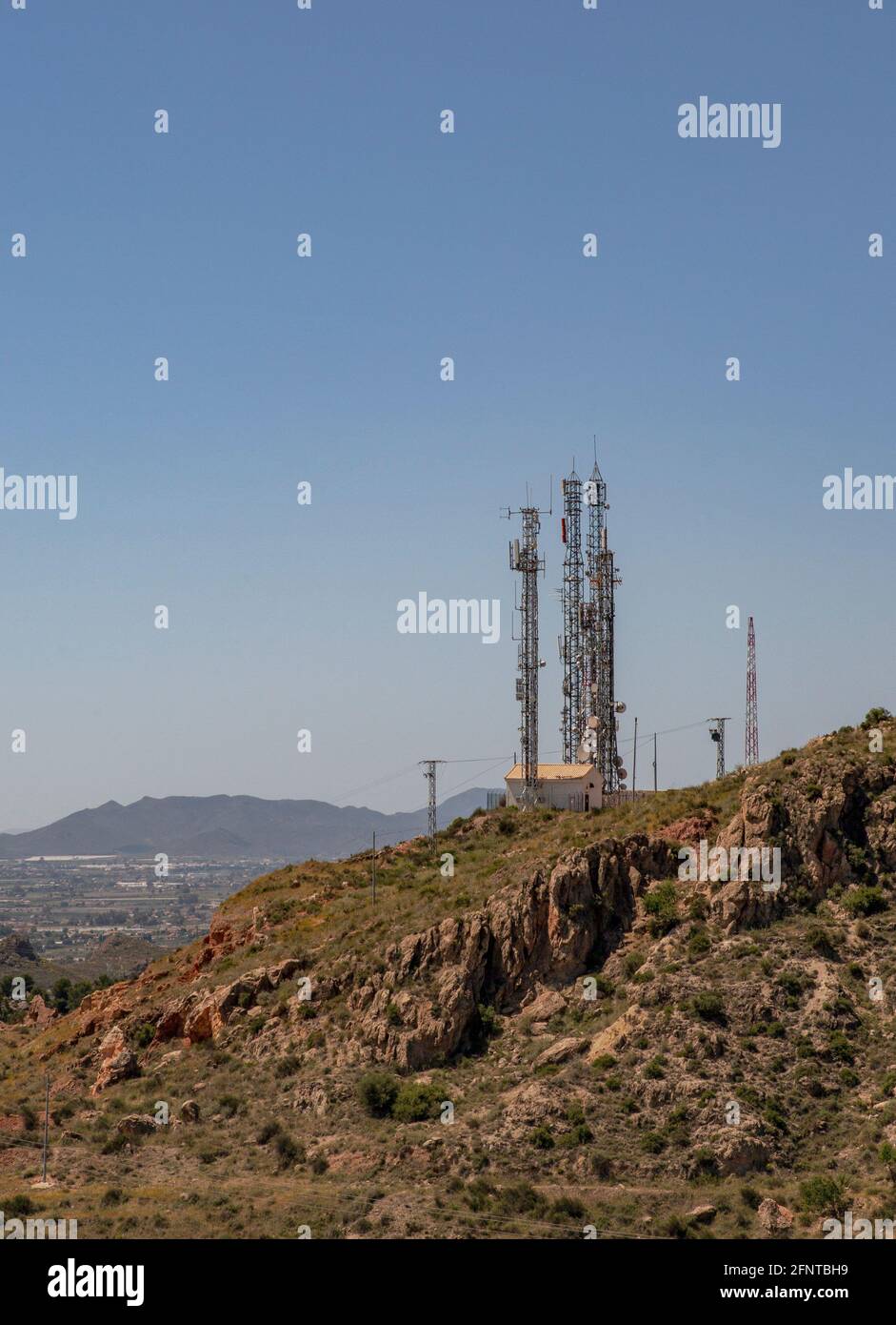 Antenna telephone and communication towers on the background of a beautiful mountain and a beautiful sky. Can be used as a background or landscape. Stock Photo