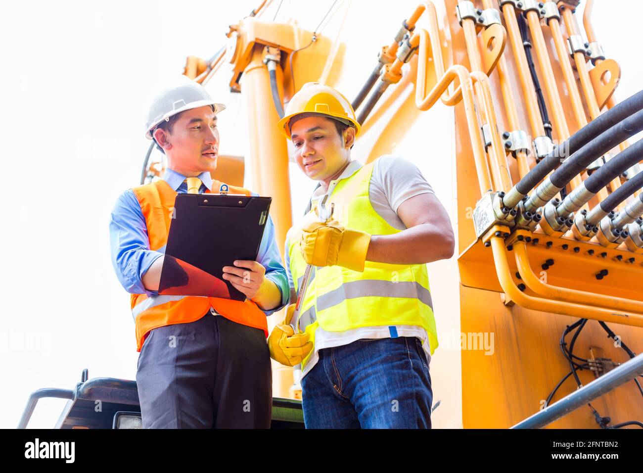 Asian motor mechanic discussing with foreman task list in vehicle workshop Stock Photo