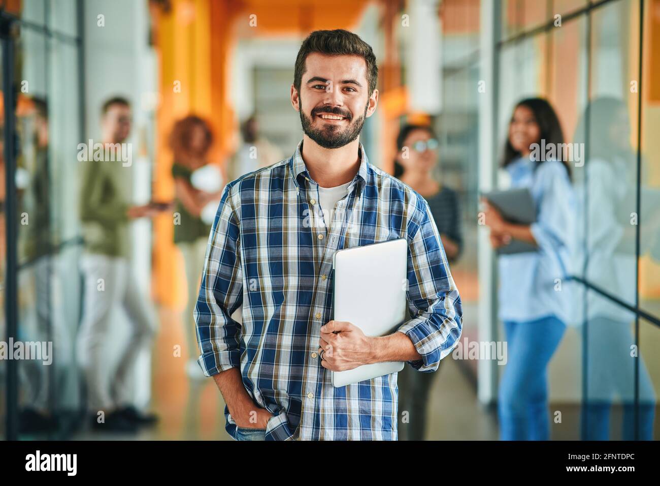 Friendly handsome man in busy hallway posing for camera Stock Photo